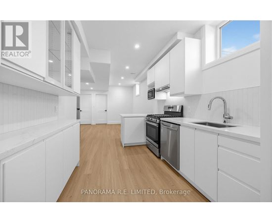 A modern kitchen with white cabinets and appliances.