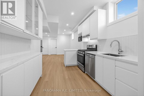 A modern kitchen with white cabinets and appliances.