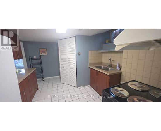 A kitchen with a sink, stove, and cabinets.