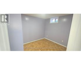 A room with a window and wooden flooring.