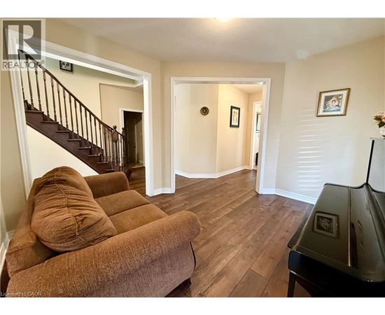 A living room with a brown couch and a piano.