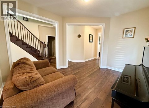 A living room with a brown couch and a piano.