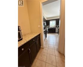 A kitchen with black cabinets and a microwave on the counter.