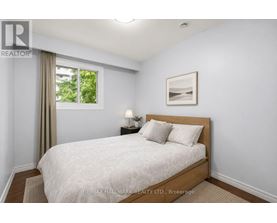 A bedroom with a large bed and a window with curtains.