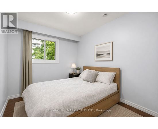 A bedroom with a large bed and a window with curtains.