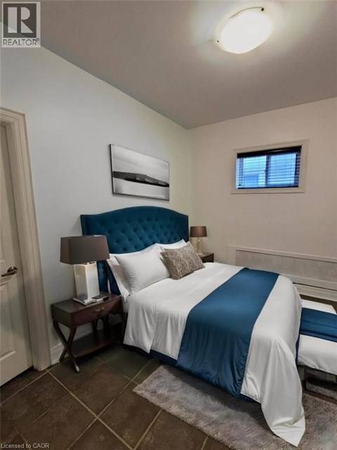 A bedroom with a bed, nightstand, and lamp.
