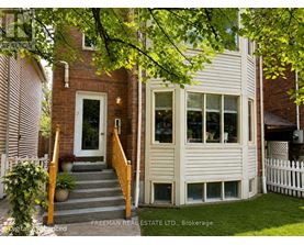 A house with a white fence and a brick wall.