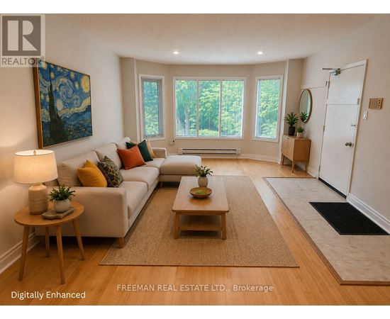 A well-lit living room with a white sofa, wooden coffee table, and a painting on the wall.