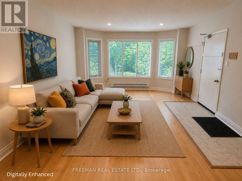 A well-lit living room with a white sofa, wooden coffee table, and a painting on the wall.
