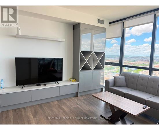 A modern living room with a flat screen TV and a large window overlooking the city.