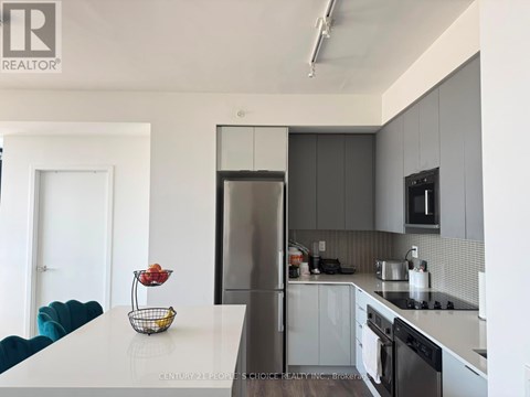A modern kitchen with a white countertop and grey cabinets.