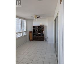 A room with a fan, a cabinet, and a shelf.