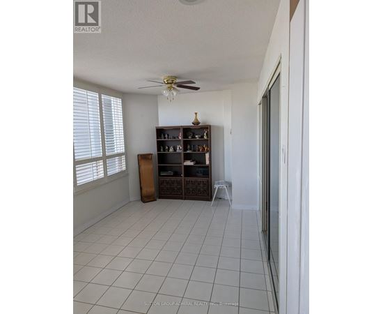 A room with a fan, a cabinet, and a shelf.