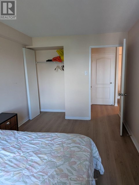 A bedroom with a bed, dresser and closet.