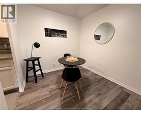 A room with a table and chairs and a framed picture on the wall.