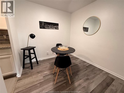 A room with a table and chairs and a framed picture on the wall.