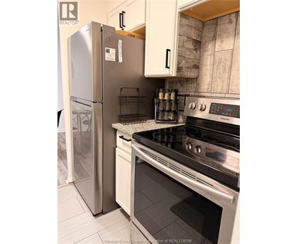 A kitchen with a stainless steel refrigerator and a stainless steel oven.