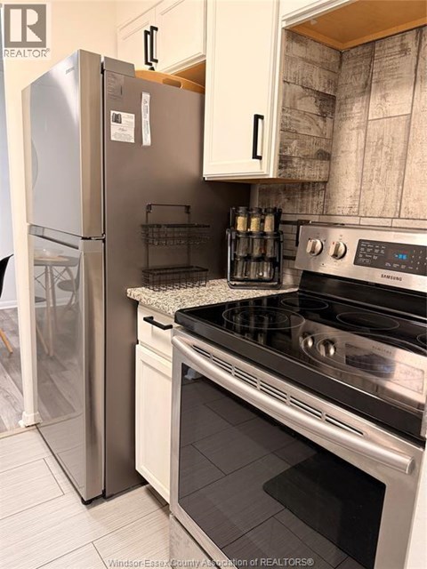 A kitchen with a stainless steel refrigerator and a stainless steel oven.