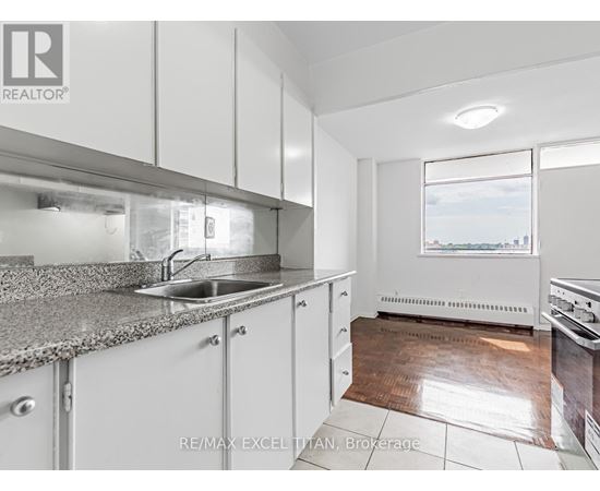 A kitchen with white cabinets and a granite countertop.