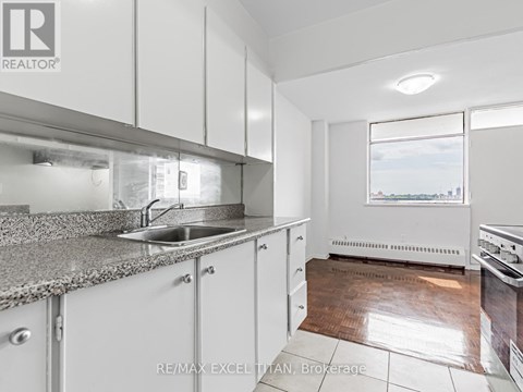A kitchen with white cabinets and a granite countertop.