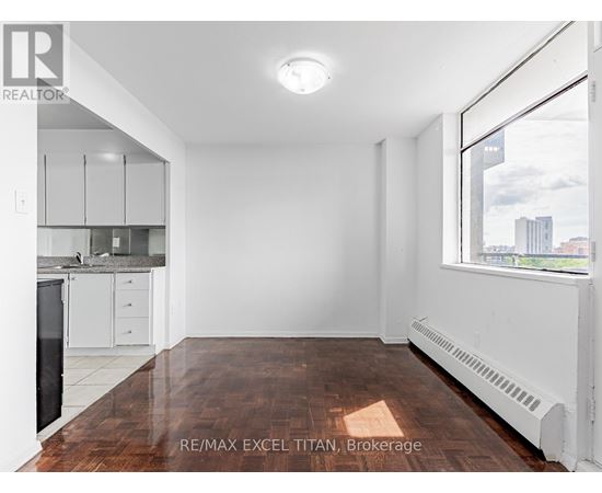 A spacious, empty room with a window overlooking a cityscape.