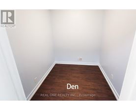 A den room with a wooden floor and white walls.