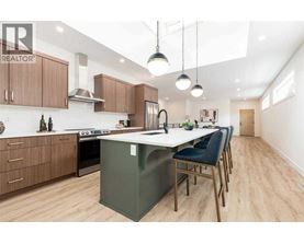 A modern kitchen with wooden cabinets and a green island.