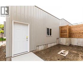 A metal building with a white door and a window is under construction.