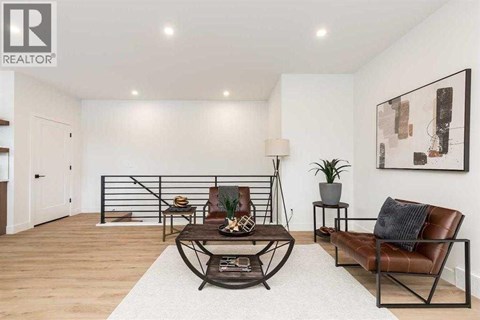 A living room with a brown leather chair and a white rug.