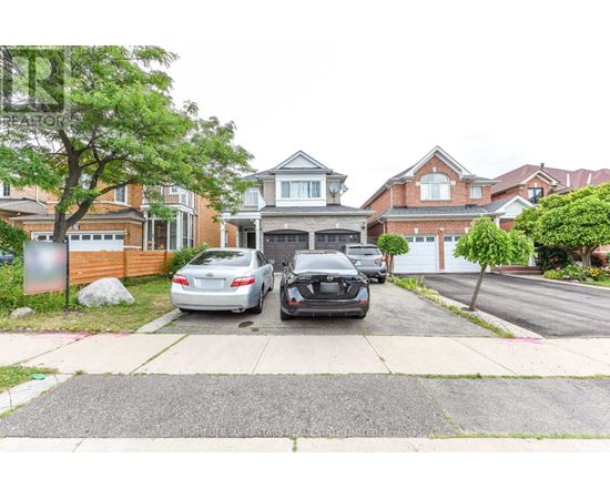 Two cars are parked in front of a house.