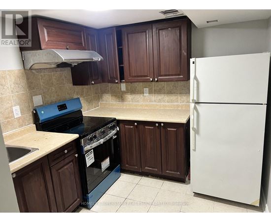A kitchen with brown cabinets and a white refrigerator.