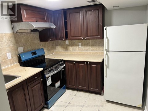A kitchen with brown cabinets and a white refrigerator.
