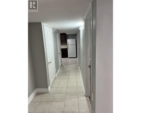A hallway with a white door and a white wall.