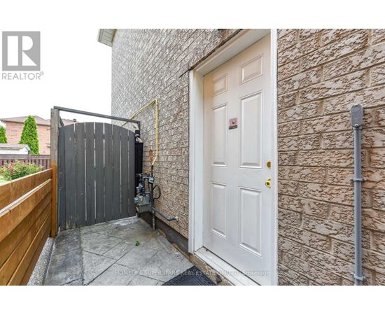 A white door is on the right side of a brick wall.