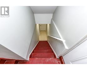 A staircase with red steps and white walls.