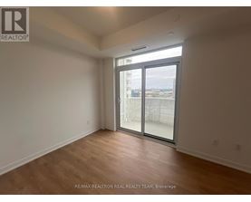 A room with a sliding glass door leading to a balcony.