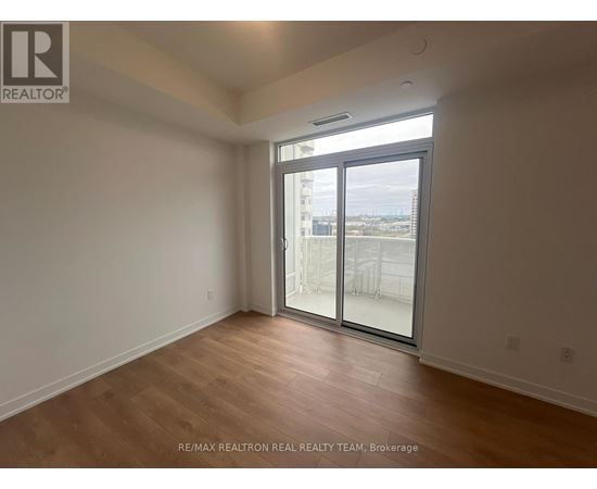 A room with a sliding glass door leading to a balcony.
