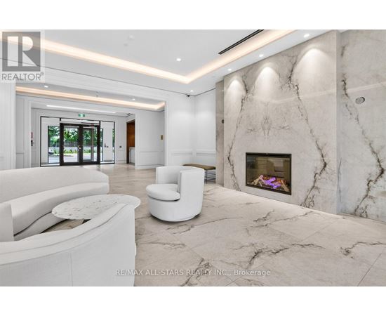 A white living room with a marble fireplace and a large window.