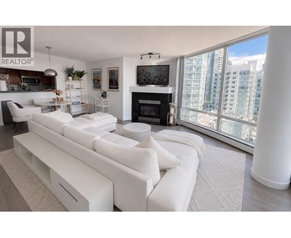 A living room with a white couch and a fireplace.