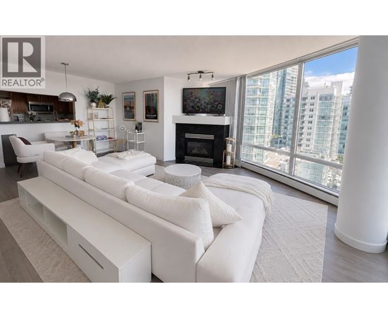 A living room with a white couch and a fireplace.