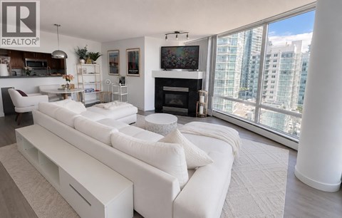 A living room with a white couch and a fireplace.
