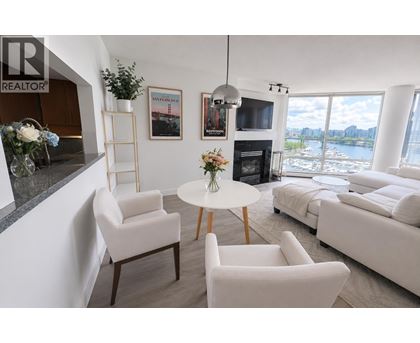 A living room with a fireplace and a view of the water.
