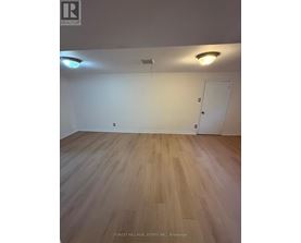 A room with wooden flooring and a white door.