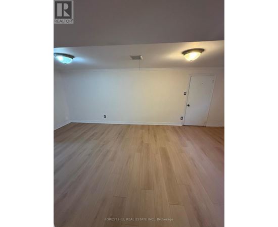 A room with wooden flooring and a white door.