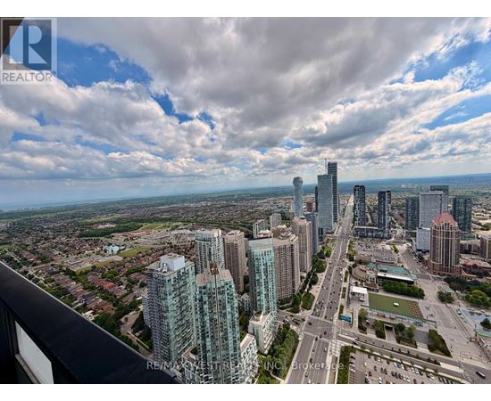 A cityscape with tall buildings and a cloudy sky.