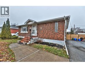 A house with a red brick exterior and a white door is for sale.