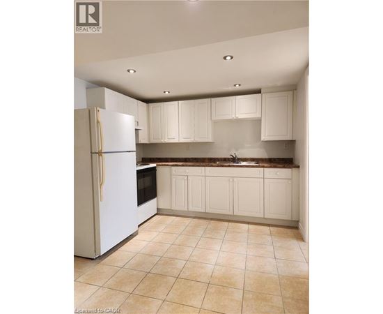 A kitchen with a white refrigerator and cabinets.