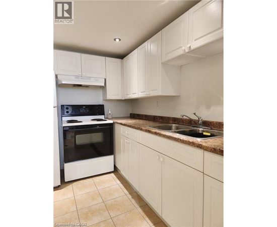 A kitchen with white cabinets and a black stove top oven.
