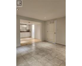 A spacious room with a tiled floor and a door leading to another room.