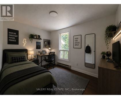 A bedroom with a bed, desk, and chair.